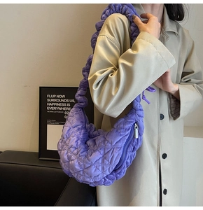 Model wearing a purple quilted cloud bag in a minimalist indoor street style setting