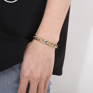 Close-up of gold and silver two-tone flat link chain bracelet worn on a male wrist