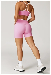 Detail van roze yoga-set met hoge taille shorts en sportbeha met gekruiste bandjes