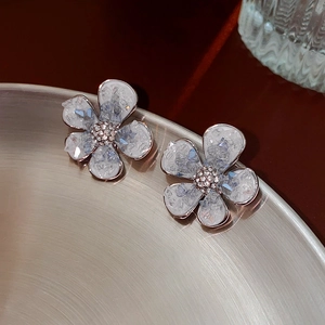 Elegant silver flower stud earrings with blue crystals and pearls in 45-degree view