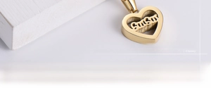 Macro view of gold heart pendant featuring a hollow Smile cutout and polished finish
