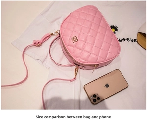 Pink quilted half-round bag compared with smartphone showing the compact size