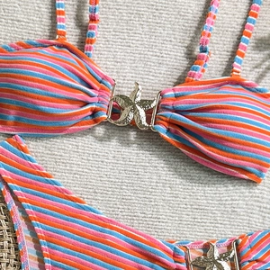 Close-up of orange and blue striped bikini with gold starfish metallic hardware