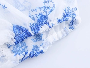 Detailansicht der elastischen Manschette eines blau-weißen Kleides mit floralem Druckmuster