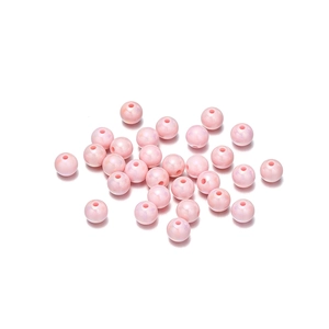 Macro shot of pile of pink acrylic round beads with pearlescent finish for DIY jewelry