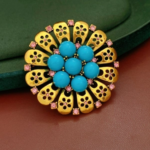 Close-up of vintage resin flower brooch with turquoise beads and pink rhinestones