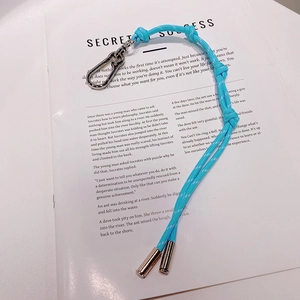 Porte-clés corde tressée bleu ciel avec mousqueton argent sur page de livre