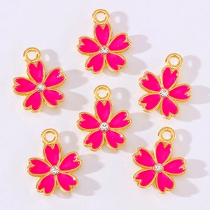 Detailed view of six pink enamel cherry blossom pendants with rhinestones for DIY jewelry