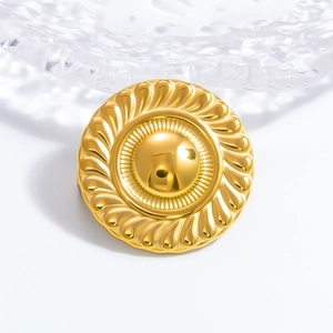 Macro detail of sunburst golden metal brooch featuring spiral rope edges and polished core