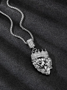 Close-up of silver lion head pendant with crown and rhinestones on a metal chain