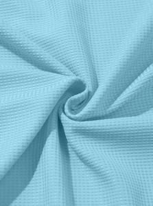 Close-up of light blue waffle weave fabric showing soft texture and premium quality