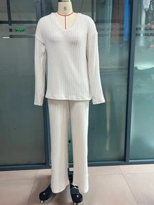 Detail of beige ribbed knit fabric on V-neck top and wide-leg trousers set