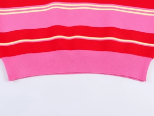 Close-up of vibrant red and pink striped knit polo shirt with ribbed hem detail