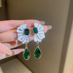 Vintage fan-shaped white petal earrings with green crystal drops and starburst lighting