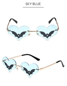 Detail view of sky blue heart sunglasses with black bat silhouette and gold metal frame
