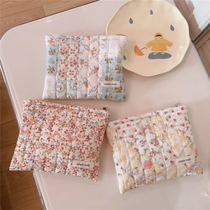 Close-up of quilted cotton floral cosmetic bags in blue, red, and yellow patterns