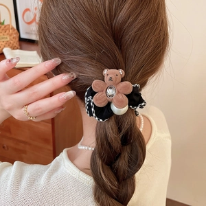 Detail of cute bear hair tie with pearl and heart crystal on a ponytail hairstyle