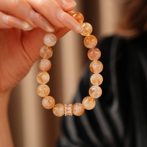 Gros plan détaillé du bracelet en cristal jaune avec perle en métal doré sertie de zircons