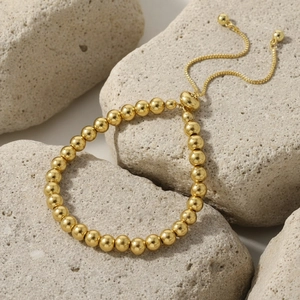 Detailed shot of gold plated beaded bracelet featuring adjustable sliding clasp on stone