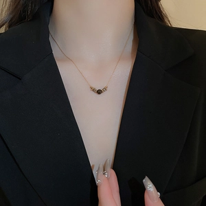 Close-up of golden beaded tiger eye necklace worn on a black blazer outfit for women