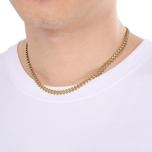 Detail of golden wheat chain necklace featuring heart-shaped links on male neck