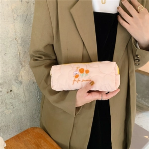 Detailed embroidery of tulips and characters on a soft pink quilted pencil case