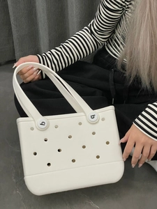 Detail of white EVA beach tote bag showing perforated holes and circular handle buckles
