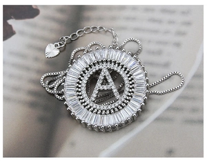 Macro detail of silver necklace with letter A pendant and sparkling zircon stones