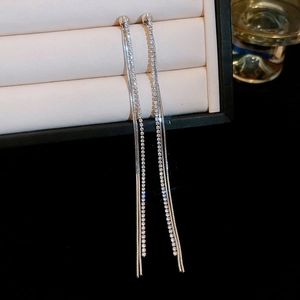 Detail of silver long tassel earrings with sparkling rhinestones on jewelry tray