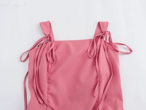 Détail d'une robe courte rose avec bretelles réglables à nouer au design élégant