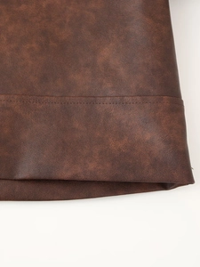 Vue macro de la texture en simili cuir marron et détails de couture sur l'ourlet