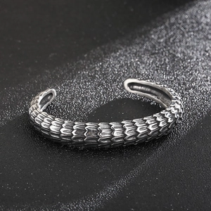 Punk vintage silver dragon scale cuff bracelet with intricate metal textures on dark surface