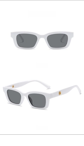Detailansicht der weißen rechteckigen Kinder-Sonnenbrille mit grauen Gläsern und Gold