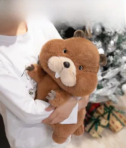 Close-up of cute plush marmot doll with detailed fur held by a model in Christmas setting