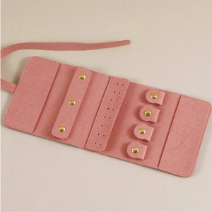 Pink microfiber jewelry roll organizer with internal compartments for earrings and necklaces