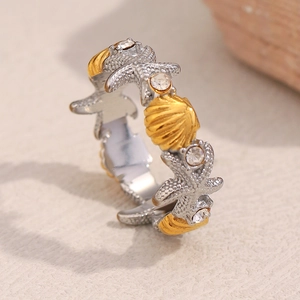 Detailed macro view of 18K gold starfish and seashell ring with white rhinestones
