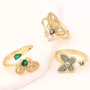 Detailed macro view of gold-plated butterfly rings with colorful zircon and evil eye motif