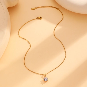 Détail de la chaîne dorée en acier inoxydable avec pendentif rond en zircon brillant