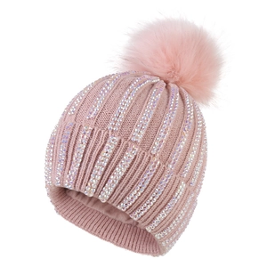 Detail of pink knitted beanie featuring sparkling colorful rhinestones and a large fluffy pom-pom