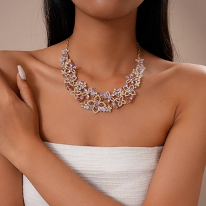 Detailed view of luxury gold hollow flower necklace with purple and clear crystals