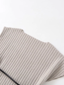 Macro shot of light grey ribbed knit fabric showing detailed texture and shoulder strap