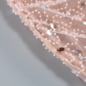 Macro shot of pink mesh evening gown fabric with shimmering sequins and beadwork detail