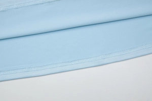 Gros plan des coutures fines et de la texture du tissu bleu clair d'une robe d'hiver
