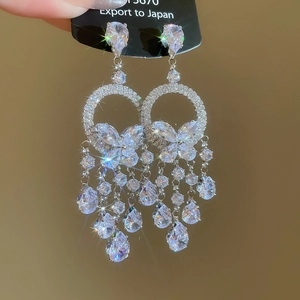 Détail de boucles d'oreilles vintage papillon avec chaînes de cristal et gouttes de gemmes