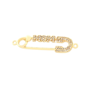 Detail of gold safety pin brooch with sparkling cubic zirconia and heart accent