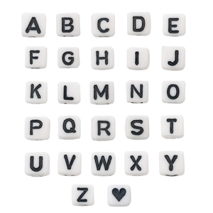 Macro detail of white square acrylic beads with black letters A-Z for DIY jewelry