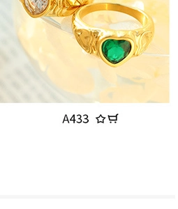 Macro view of gold heart ring featuring a vibrant green gemstone and wavy band design