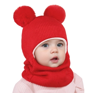 Dettaglio cappello invernale in maglia rossa per bambini con doppi pompon e scaldacollo