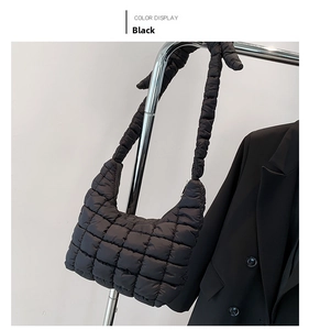 Detail of black quilted cloud hobo bag with padded texture and knotted shoulder strap