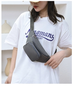 Detail of dark grey water-resistant nylon waist bag with silver zippers and multi-layers